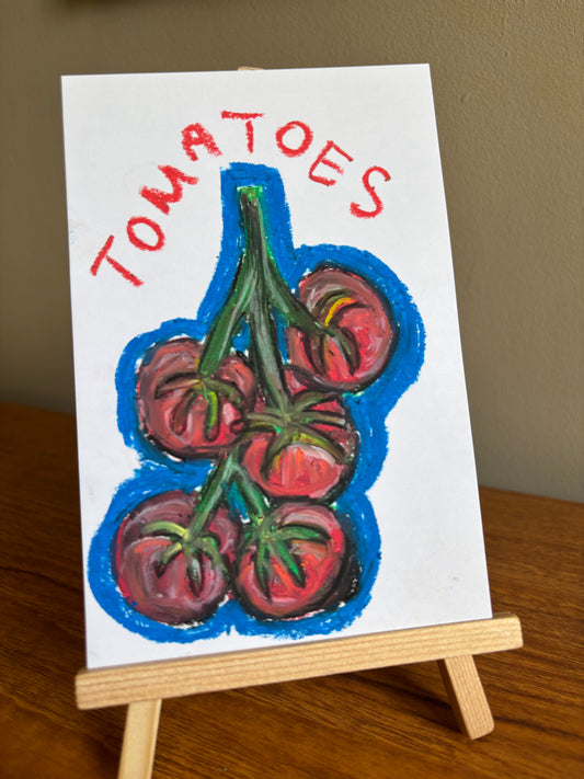 A small hand-painted canvas showing a cluster of red tomatoes on a vine with the word 'TOMATOES' written above in red, displayed on a wooden easel on a tabletop.